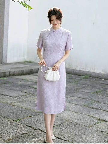 Woman in a light purple Modern Lavender A-line Short Sleeve Summer Qipao Dress  holding a white handbag on a stone path.