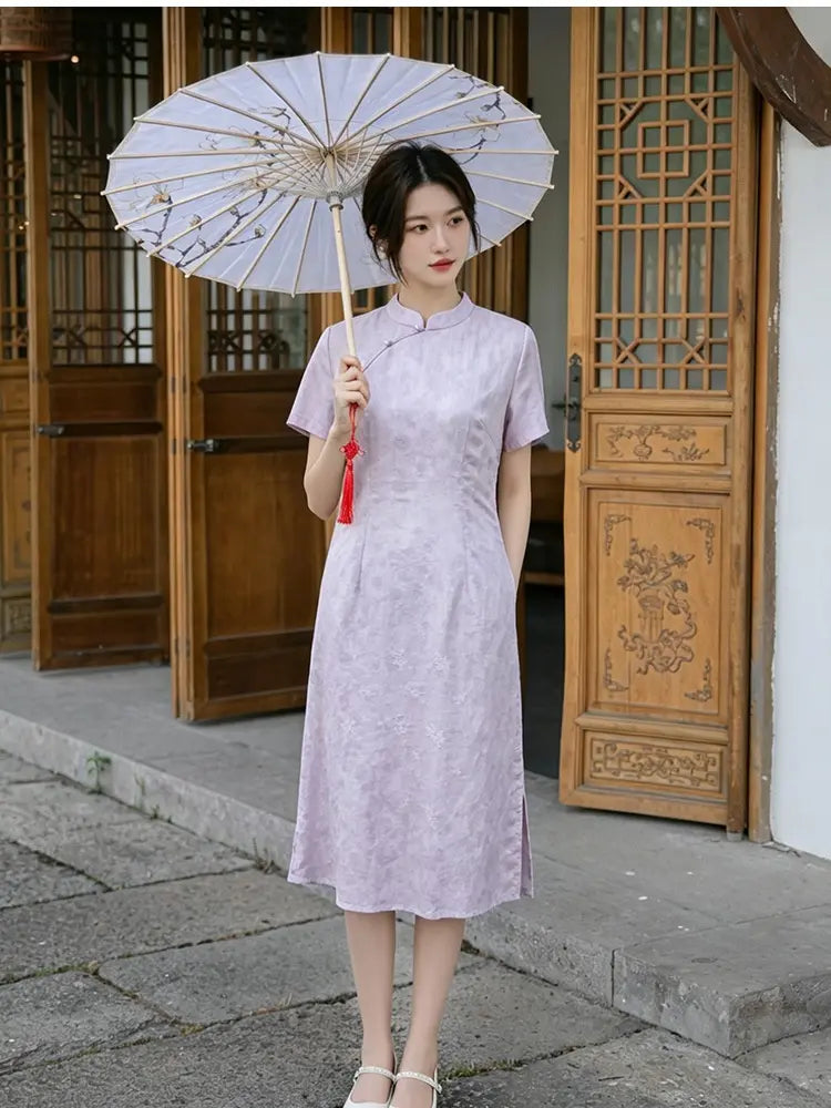 Woman in a light purple Modern Lavender A-line Short Sleeve Summer Qipao Dress  holding a traditional umbrella in front of wooden doors.
