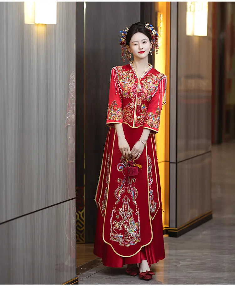 Woman in a t Modern Red Qun Kwa / Xiuhe Chinese Wedding Gown  red embroidered dress standing indoors.
