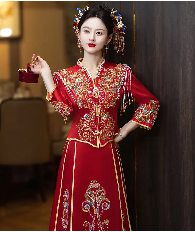Woman in a Modern Red Qun Kwa / Xiuhe Chinese Wedding Gown  with intricate designs, holding a small object.
