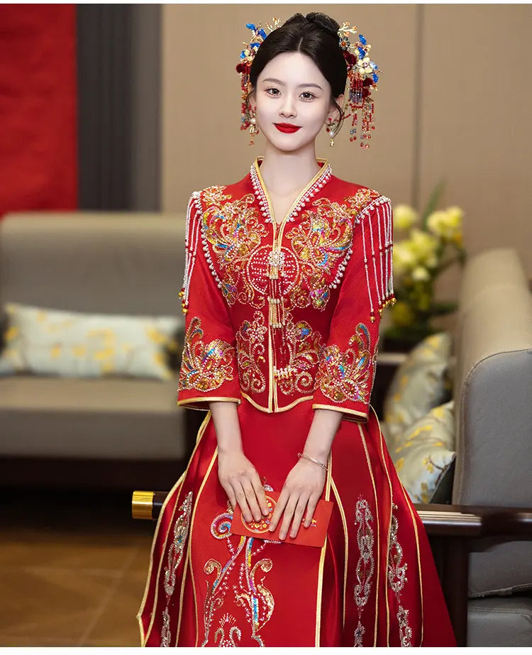 Woman in a  Modern Red Qun Kwa / Xiuhe Chinese Wedding Gownwith intricate designs, standing in an indoor setting.