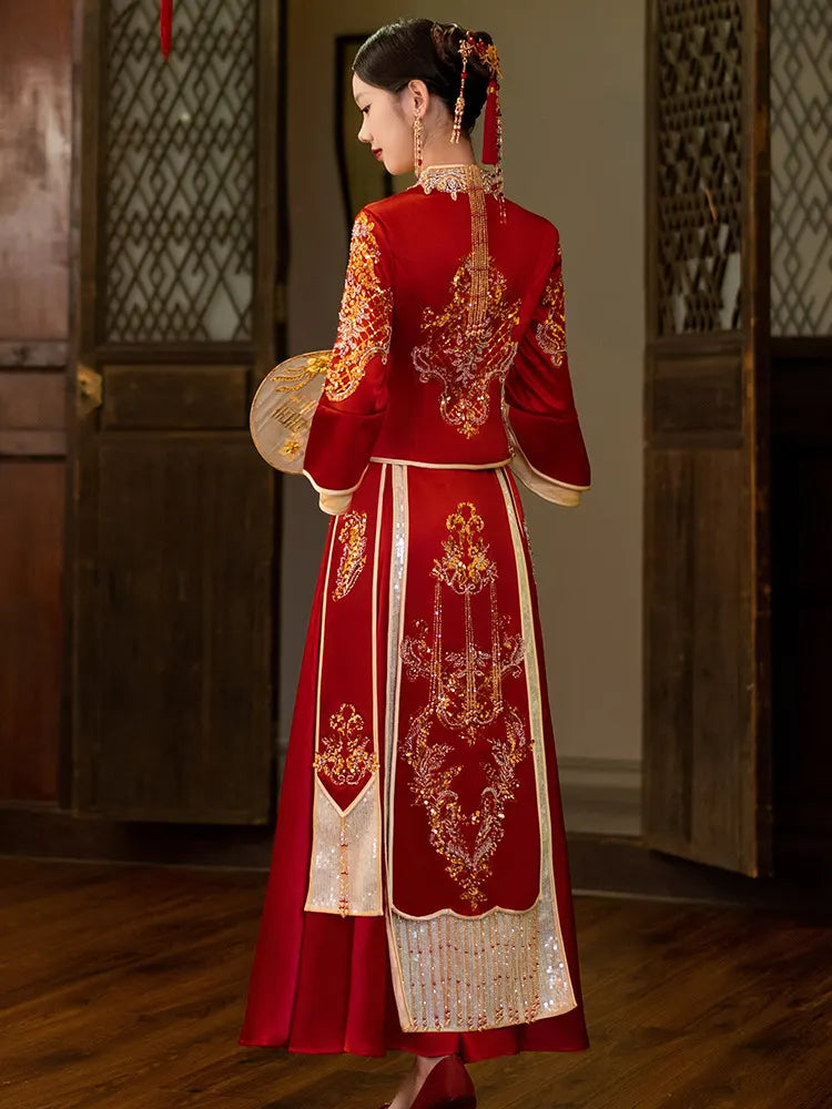 Woman in a traditional red and gold Modernized V-Neck Chinese Wedding Xiu He Qun Kwa Dress  in an indoor setting.