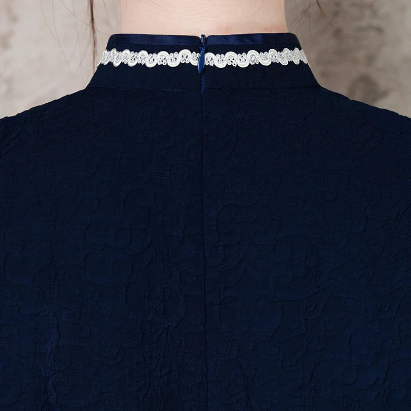 Navy blue garment with a decorative white trim on a neutral background
