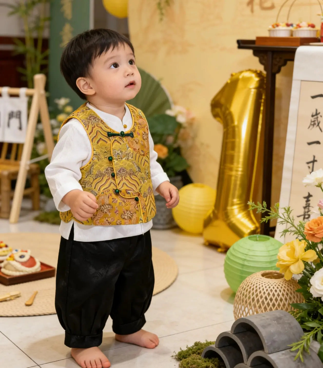 Child in a yellow New Chinese Style Baby Boy Traditional Tang Suit Dragon Vest Set  standing in a decorated room with balloons and flowers