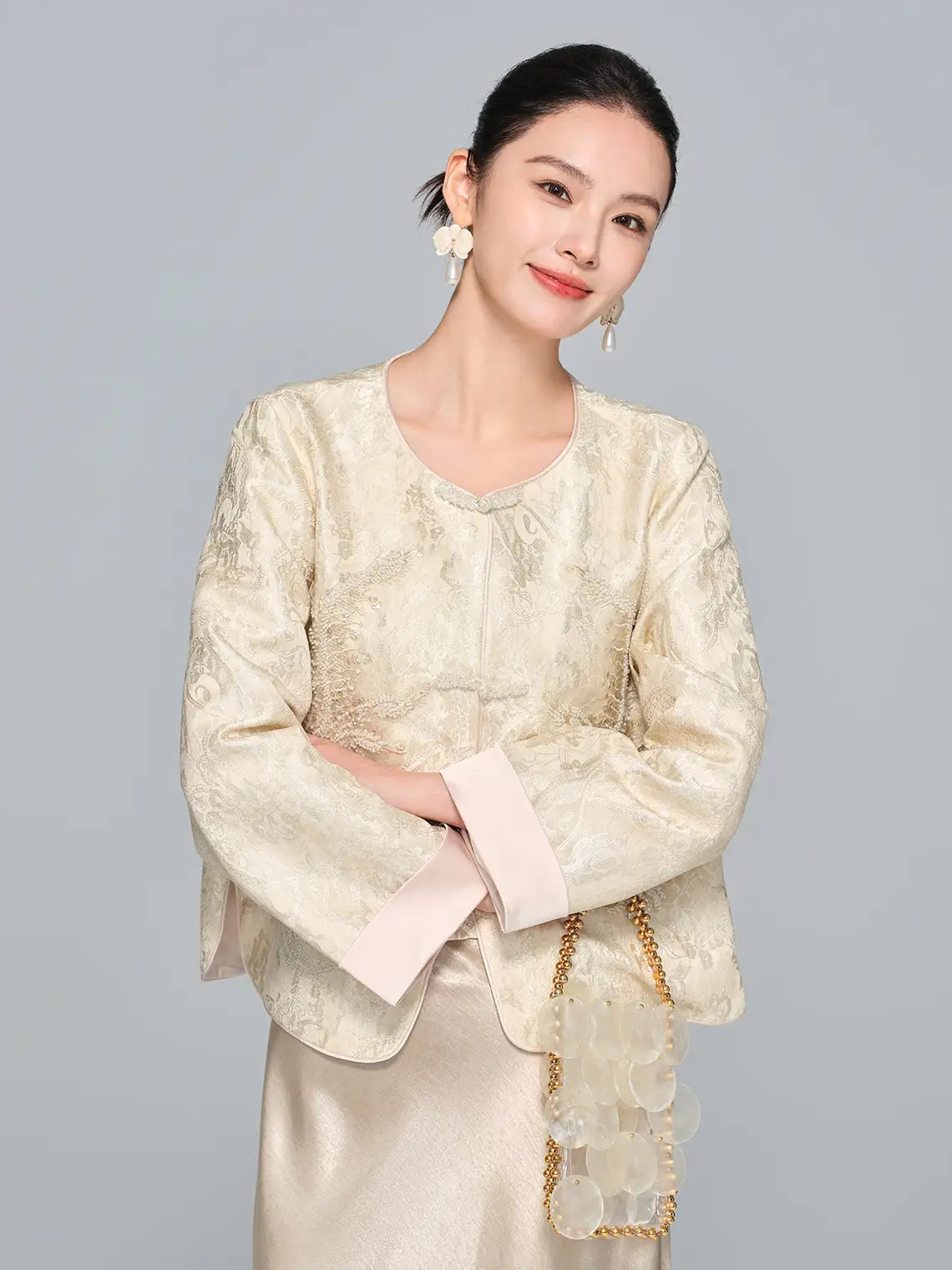 Woman wearing a New Chinese Style Champagne Gold Beaded Embroidered Jacket & Skirt with a plain background