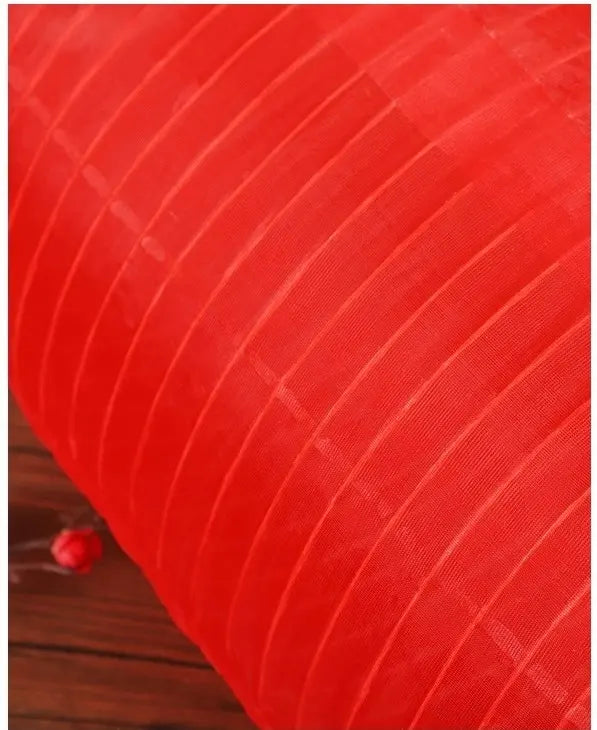 Close-up of a red textured fabric with a wooden surface underneath