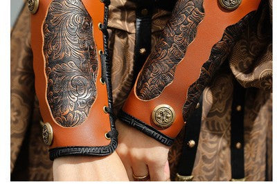 Close-up of leather arm guards with intricate designs.