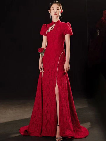 A woman modeling a floor-length red Open Back Lace Cheongsam/Qipao Dress With Train  gown with short puff sleeves, a high slit, and a train against a dark studio background.