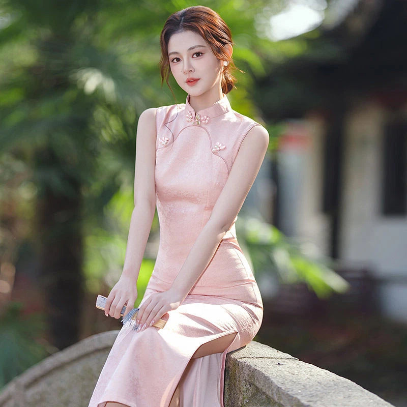 Woman in a Pastel Pink Sleeveless Modern Jacquard Qipao cheongsam  dress sitting outdoors with greenery in the background