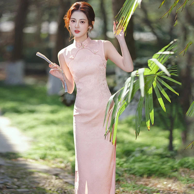 Woman in a Pastel Pink Sleeveless Modern Jacquard Qipaodress standing outdoors with greenery in the background