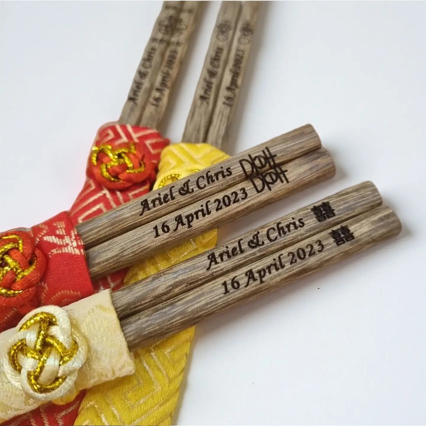 Wooden chopsticks with engraved text on a white background