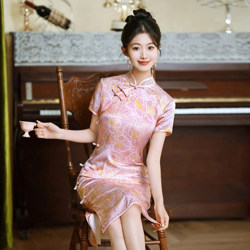 Woman in a Pink Floral Mullbury Silk Short Sleeves chinese Qipao Dress holding a teacup in a room with a piano.