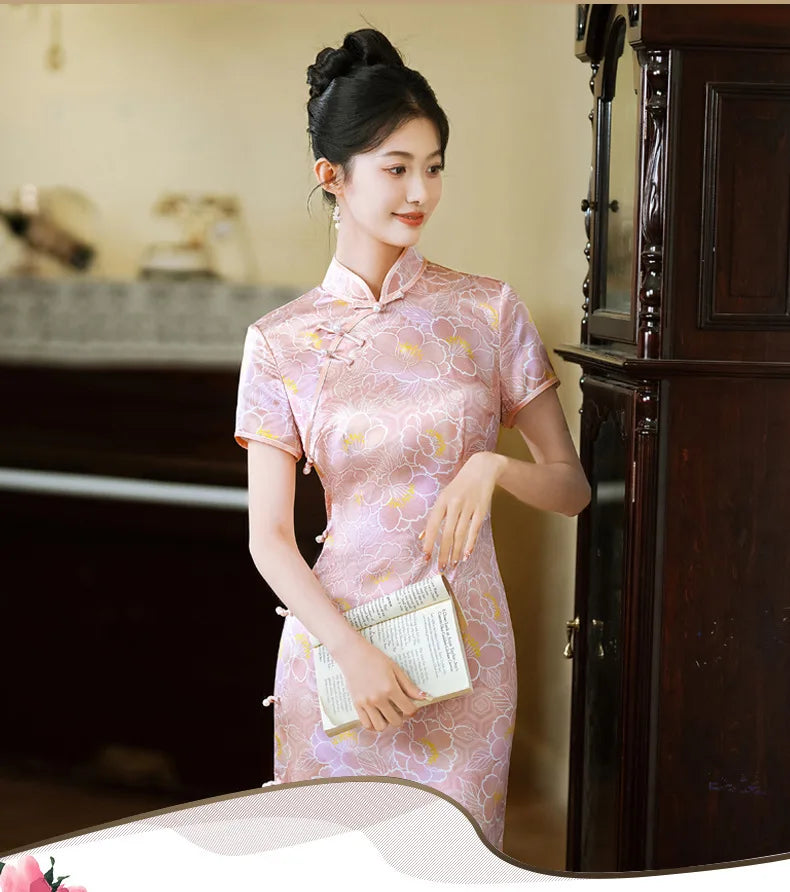 Woman in a Pink Floral Mullbury Silk Short Sleeves traditional chinese Qipao Dress  holding a book in front of a piano.