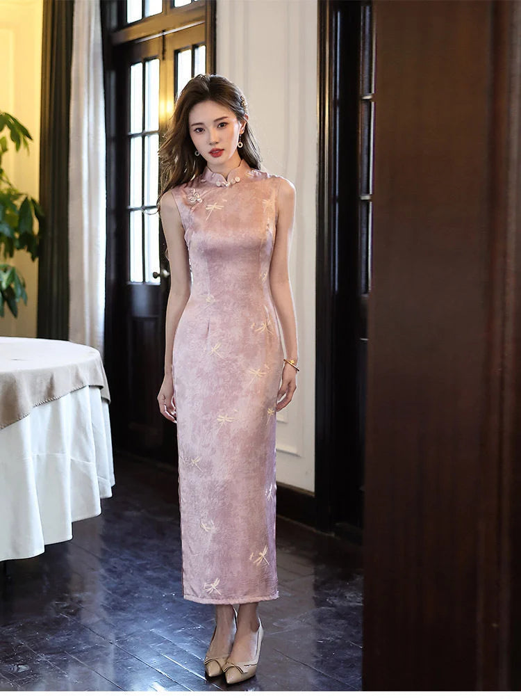 Woman in a pink floral Modern Minimalist  Sleeveless Qipao With Dragonfly Print dress standing in an elegant room with white curtains and a plant.