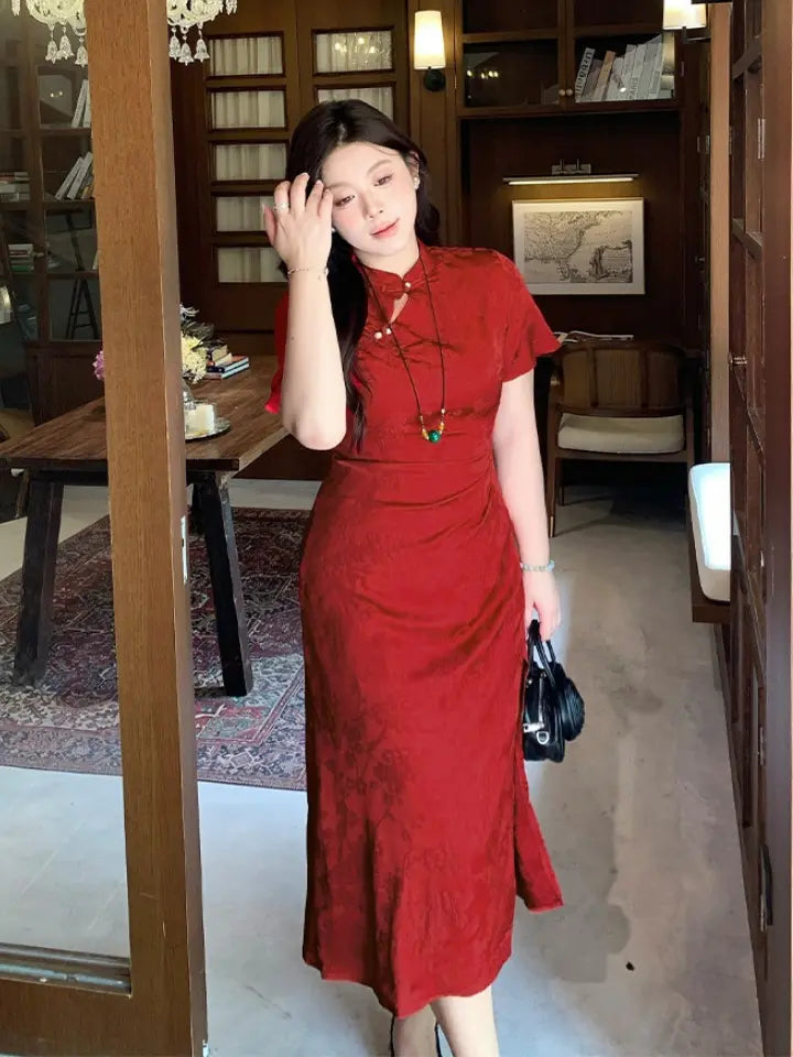 A woman wearing a Plus Size Cinnabar Red Modern midi  Qipao  cheongsam dress  standing in a warm, wood-paneled indoor setting.