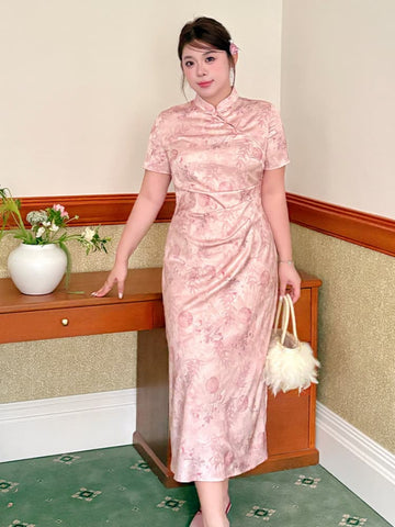 A woman wearing a Plus Size Dusty Pink  Ruched Waist Floral Qipao Cheongsam Dress , standing in a hallway next to a wooden console table and holding a fluffy white handbag.