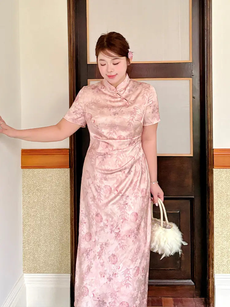 A woman wearing a pink floral-patterned plus size qipao cheongsam dress, holding a fluffy white handbag, standing in front of a dark wooden door.