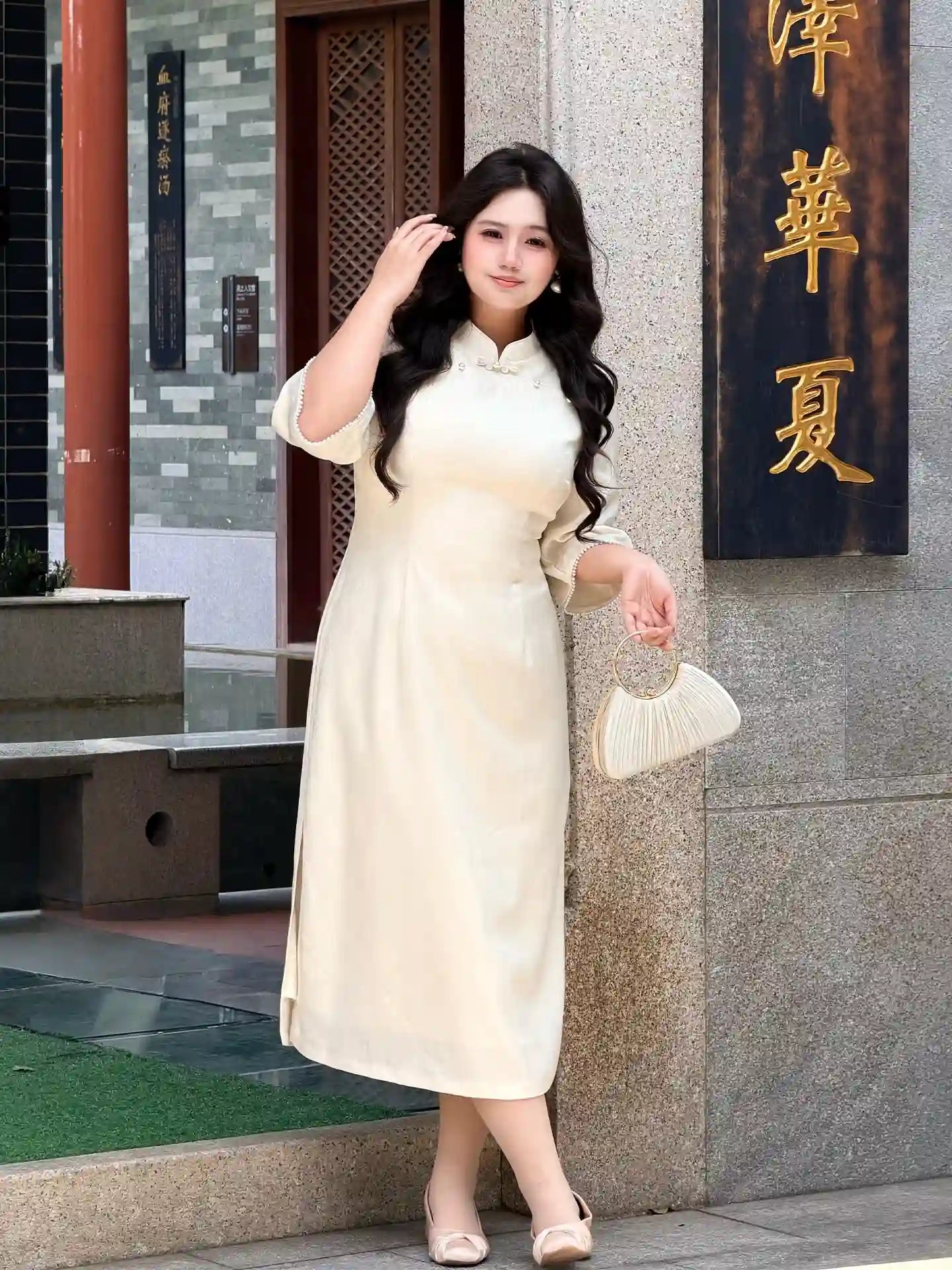 Woman in a Plus Size Ivory White Floral Long Sleeve Jacquard Qipao cheongsam dress standing in front of a building with Chinese characters.