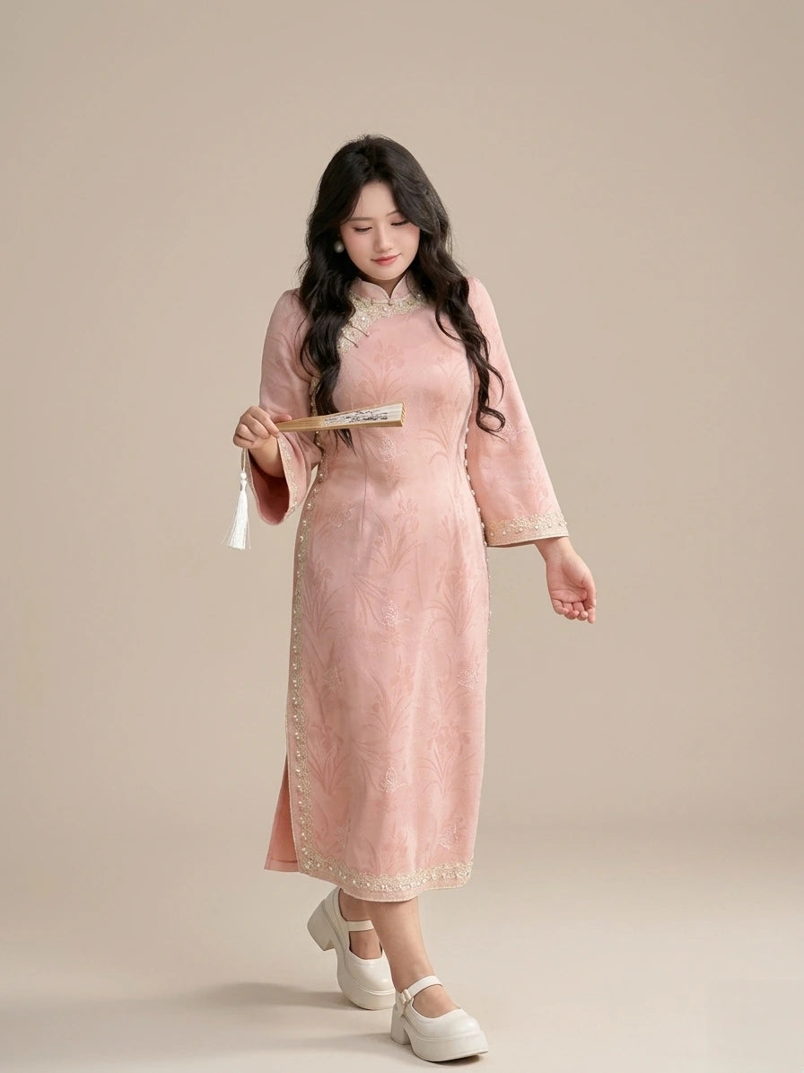 Woman in a Plus Size Long Sleeve Pink Floral traditional chinese cheongsam Qipao with Pearl Trimholding a brush against a beige background