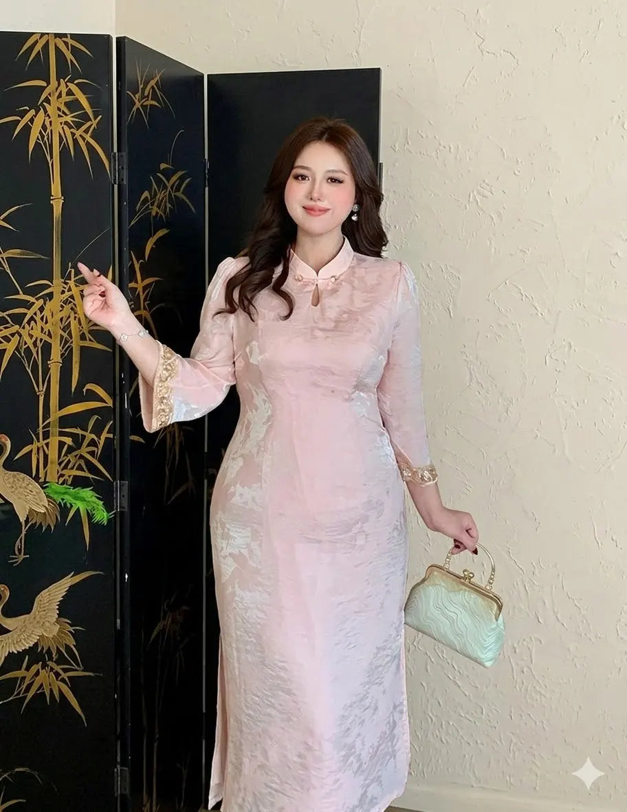 Woman in a light Plus Size Modern Pink Long Sleeve Jacquard Qipao cheongsam holding a green handbag in front of a black screen with gold bamboo designs.