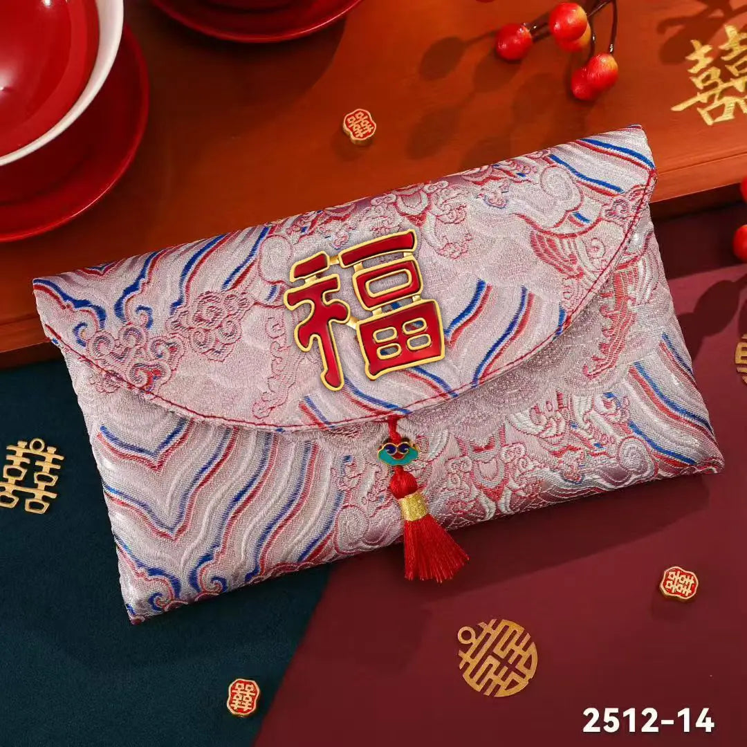 A Chinese New Year red envelope with a red and gold '福' character on a patterned brocade fabric, decorated with a red tassel, shown on a festive wooden table with red dishes and double happiness symbols.