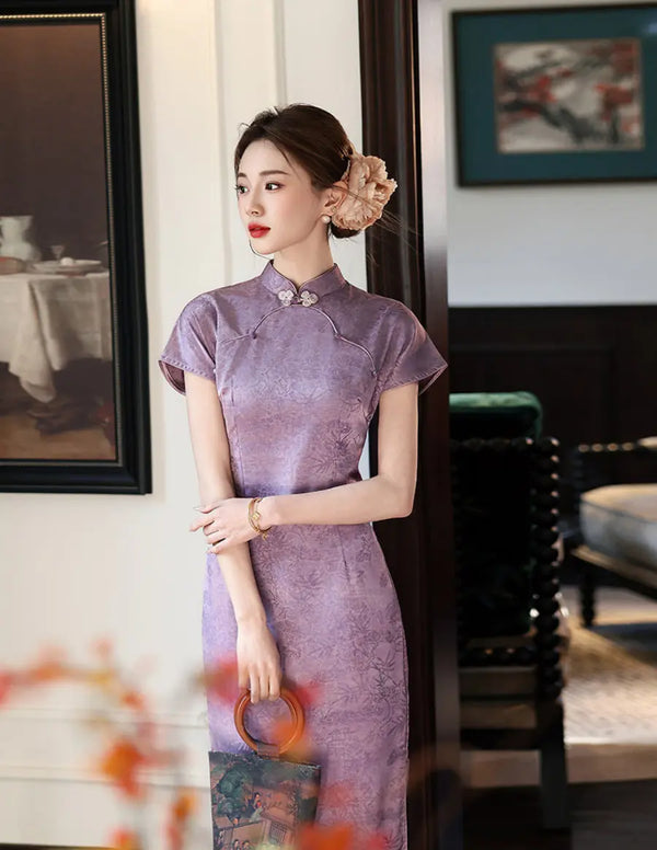Woman in a Purple Double Breasted Short Sleeve Jacquard Qipao cheongsam dress standing in an elegant room with framed pictures on the wall.