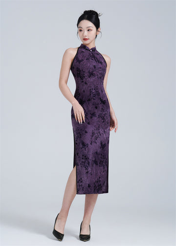 A woman wearing a purple halter neck velvet Qipao with butterfly print.