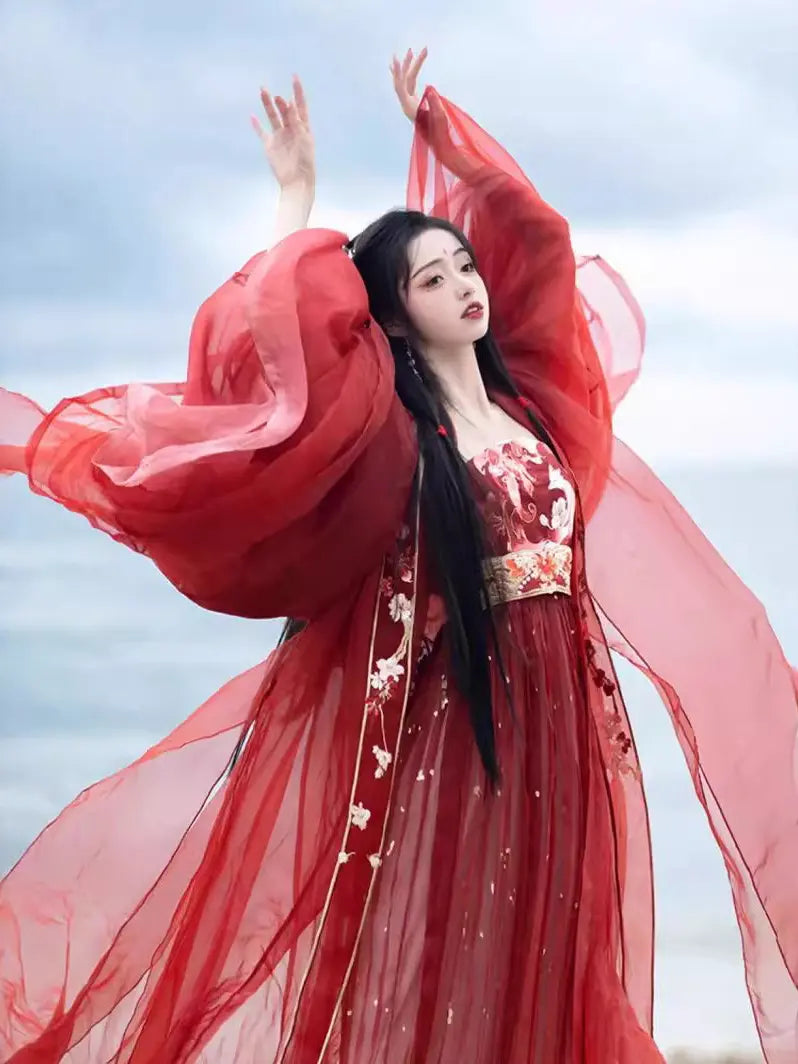 Person in a traditional Red Ancient Chinese Imperial Tang Dynasty Hanfu Set with floral patterns against a blurred natural background