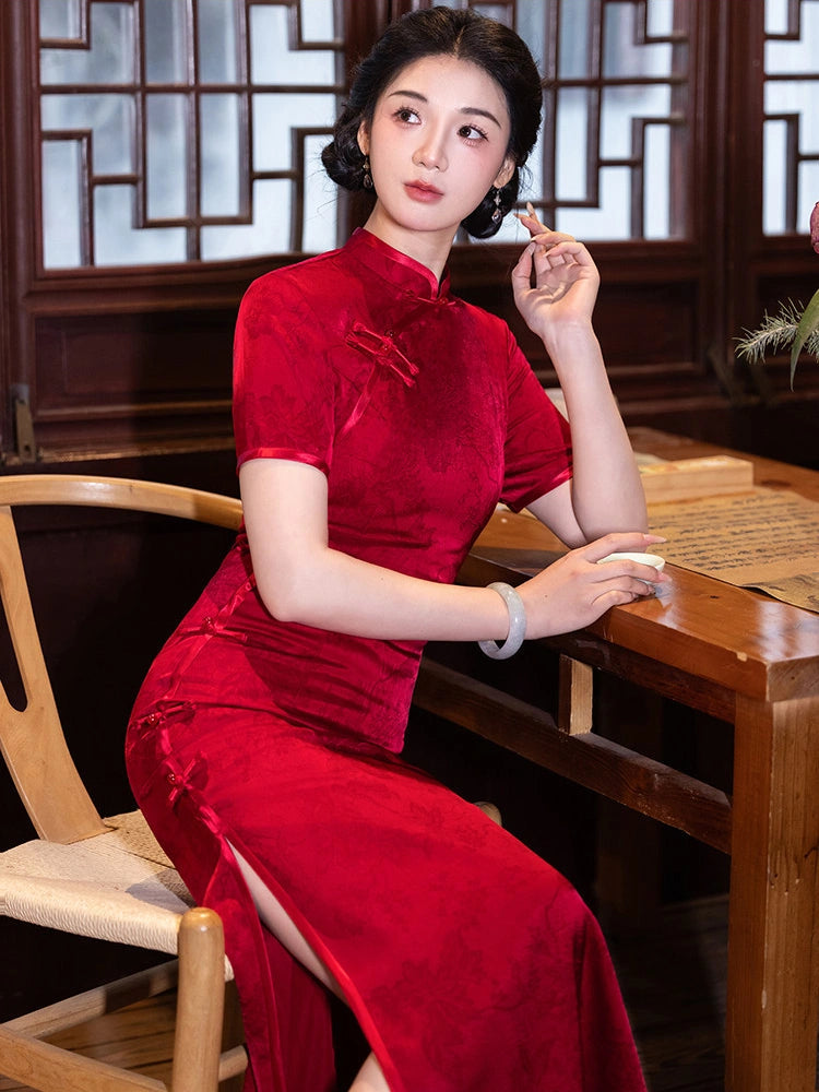 A woman wearing a red velvet cheongsam (qipao) dress sits at a wooden table in a traditional Chinese room with wooden lattice windows.