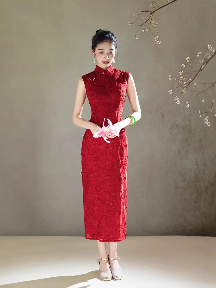 Woman in a  traditional Red Floral Embroidery Sleeveless Chinese cheongsam Qipao dress holding pink flowers against a neutral background
