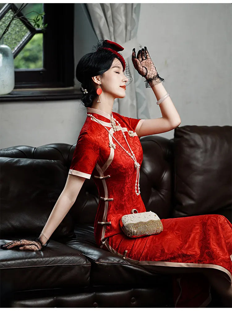 Woman in a Red & Gold Foral Jacquard Qipao - Chinese Wedding Tea Ceremony Dress  outfit sitting on a black leather couch.