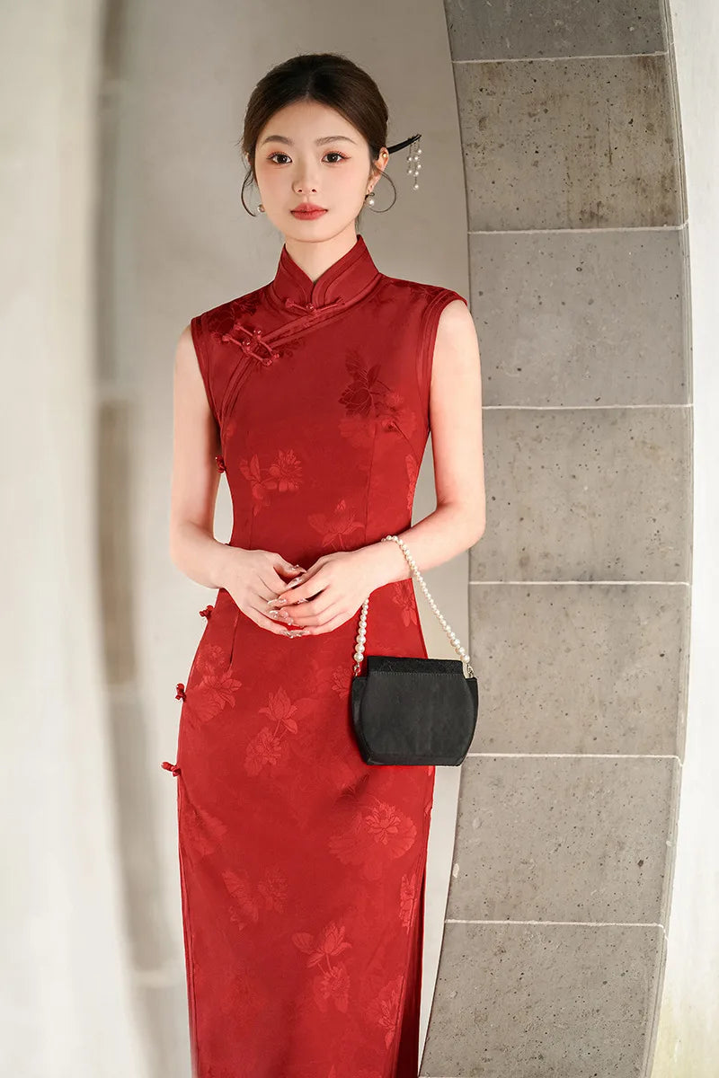Woman in a red traditional Chinese Jacquard Sleeveless Modern Qipao Dress holding a black handbag against a gray wall.