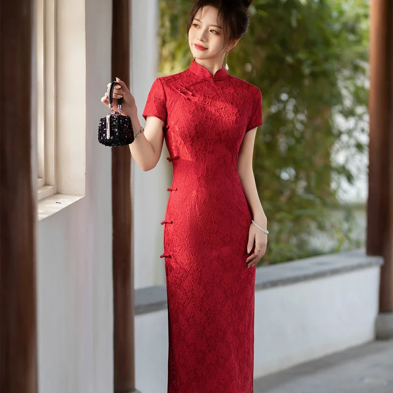 Woman in a Red Lace Midi Length Short Sleeves Chinese Qipao Dress  holding a black handbag outdoors.
