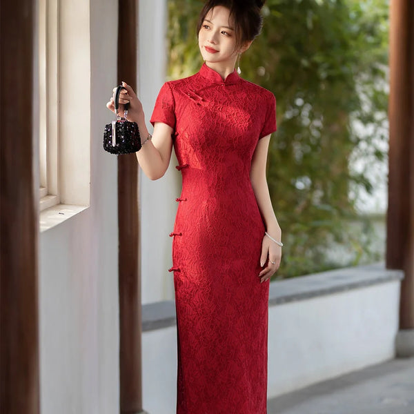 Woman in a Red Lace Midi Length Short Sleeves Chinese Qipao Dress  holding a black handbag outdoors.