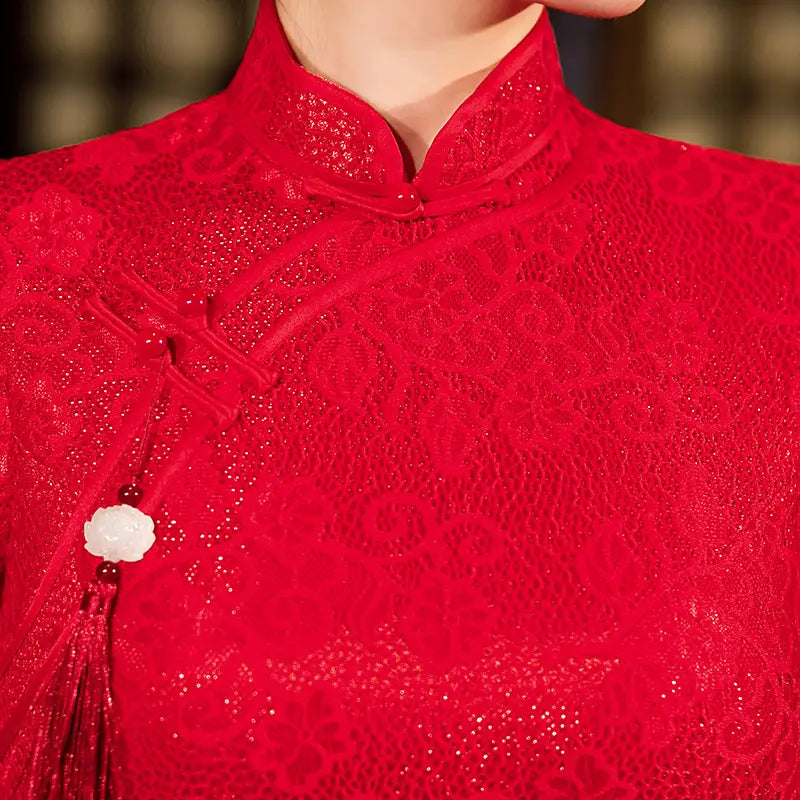 Close-up of a red lace garment with intricate patterns and decorative elements.