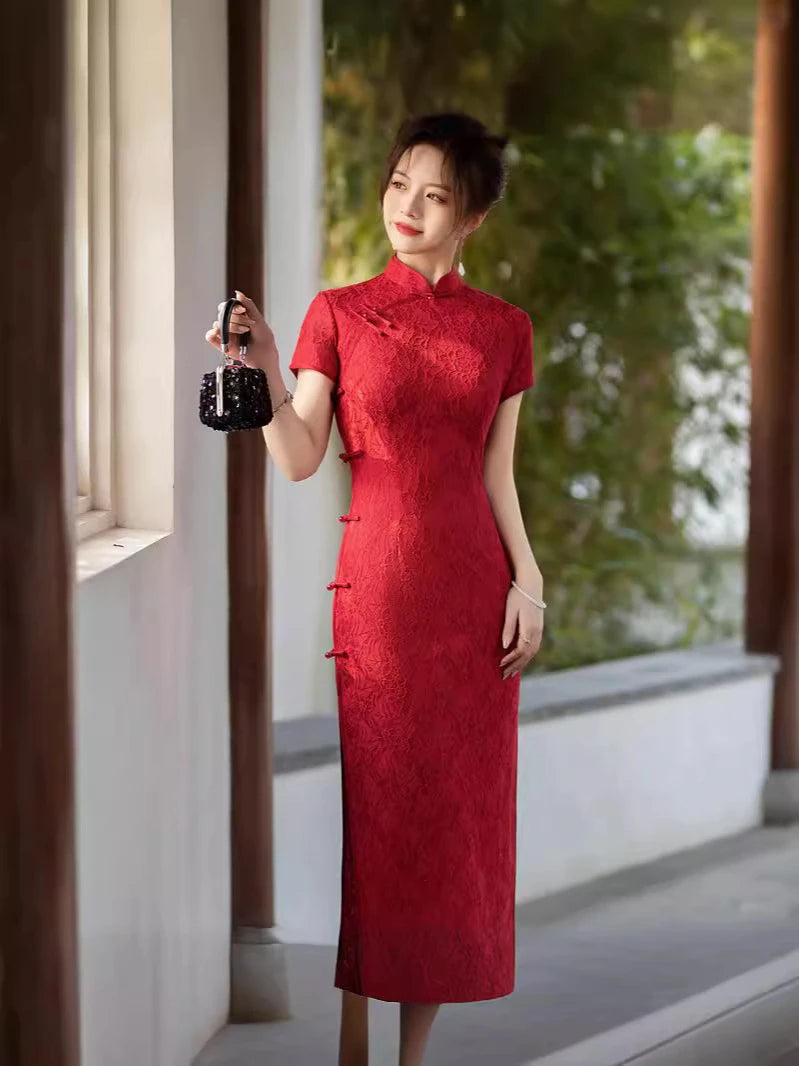 Woman in a Red Lace Midi Length Short Sleeves chinese cheongsam Dress holding a black bag indoors with greenery outside