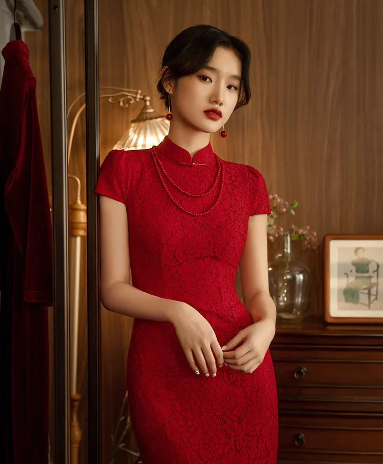 Woman in aRed Lace Open Back Cheongsam Wedding Dress standing in a room with wooden furniture and decor.