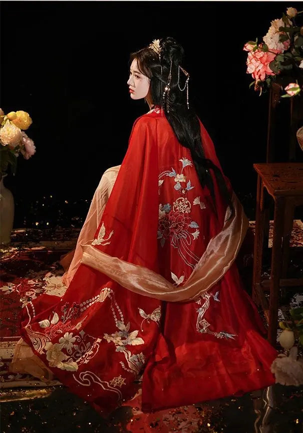 a chinese woman in traditional chinese hanfu dress with floral patterns, sitting on a chair.