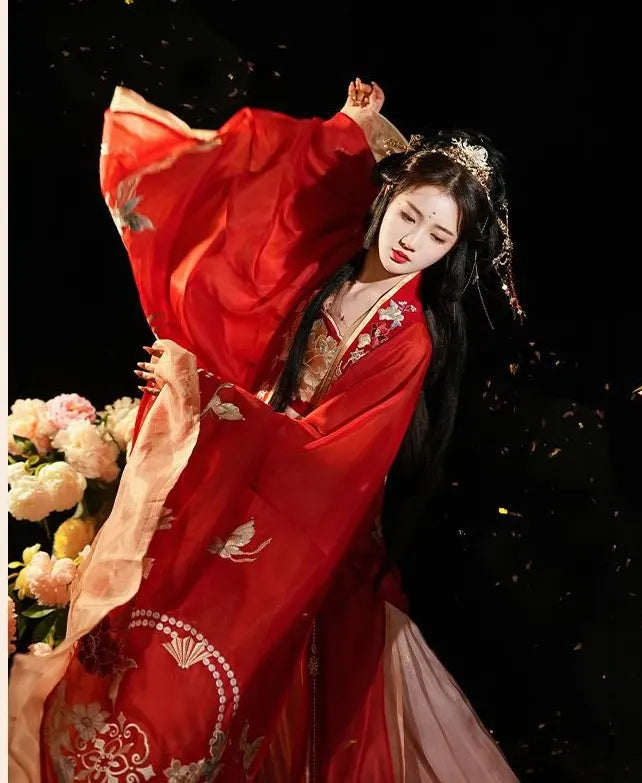 Woman in Red and Gold Tang Dynasty historical  chinese outfit  with floral decorations against a dark background