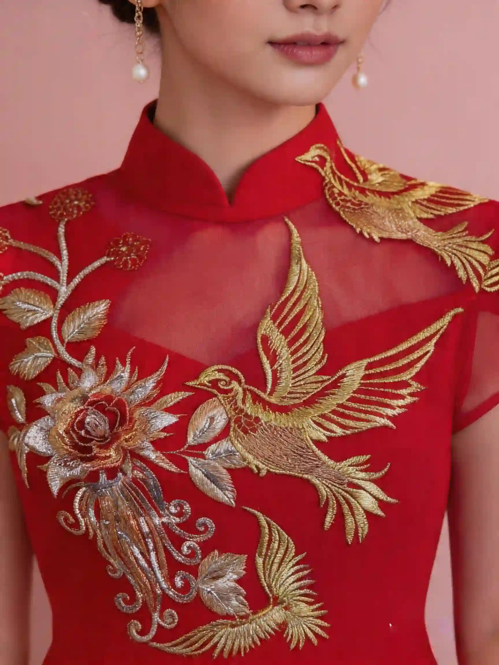 Red garment with gold embroidery of a bird and flower on a pink background