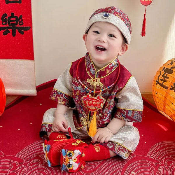 Child in Traditional Chinese Red Short Sleeves Baby Tang Jacket Set with festive decorations in the background