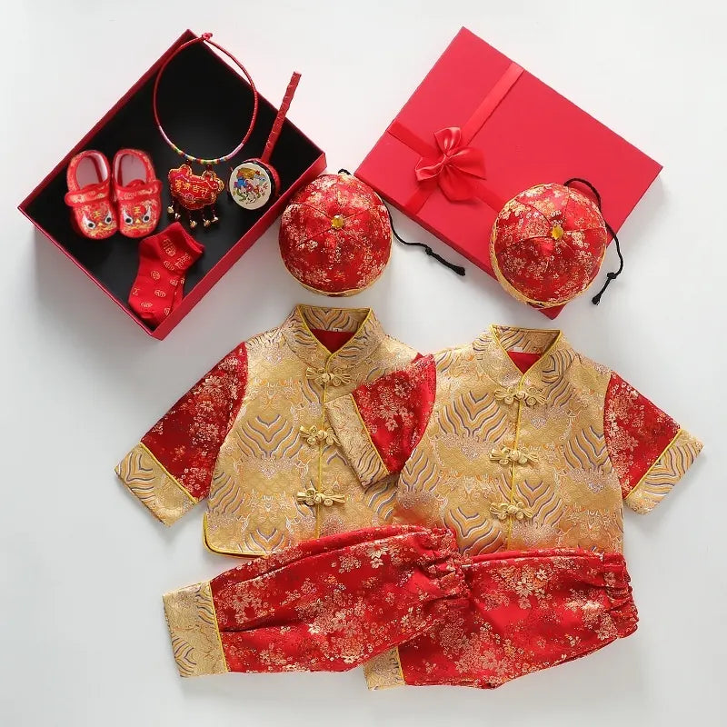 Traditional red and gold children's outfit with accessories on a white background