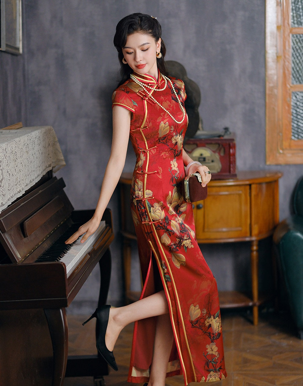 a chinese girl in red long floral silk cheongsam next to piano