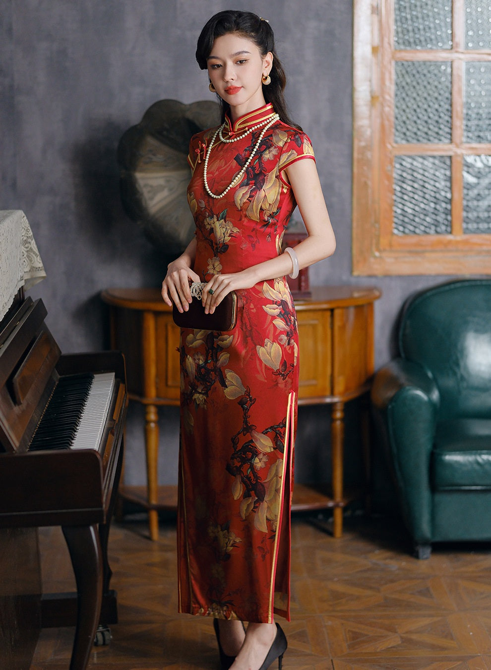 a chinese girl in red long floral silk cheongsam standing next to a piano
