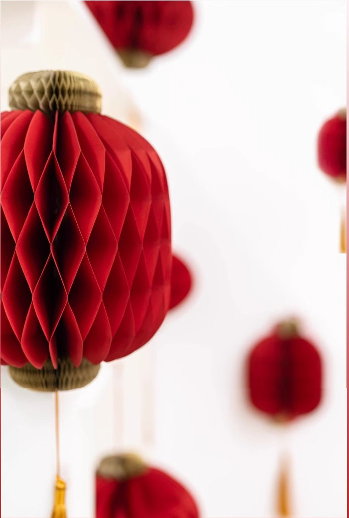  red honeycomb paper lantern with gold tassel, perfect for festive occasions like Chinese New Year or weddings