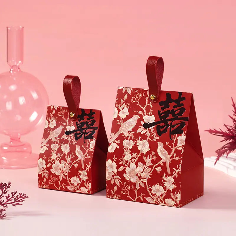 Two red Retro Chinoiserie Bird & Floral Wedding Candy Gift Boxes  with floral patterns and Chinese characters on a pink background