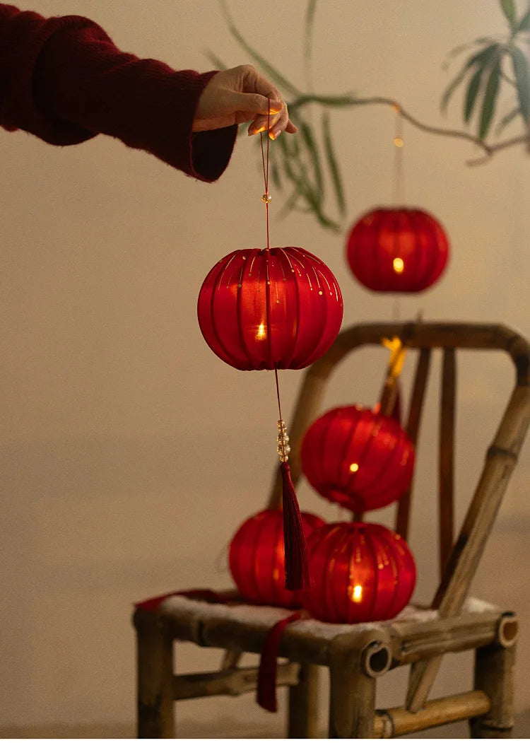 Round Red Fabric Lantern with Light and Tassels for Lunar New Year, Mid-Autumn Festival, weddings, and other celebrations.