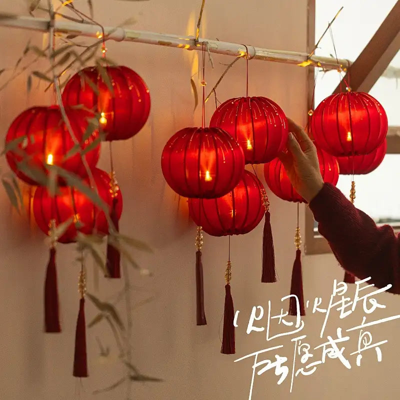 Round Red Fabric Lantern with Light and Tassels for Lunar New Year, Mid-Autumn Festival, weddings, and other celebrations.