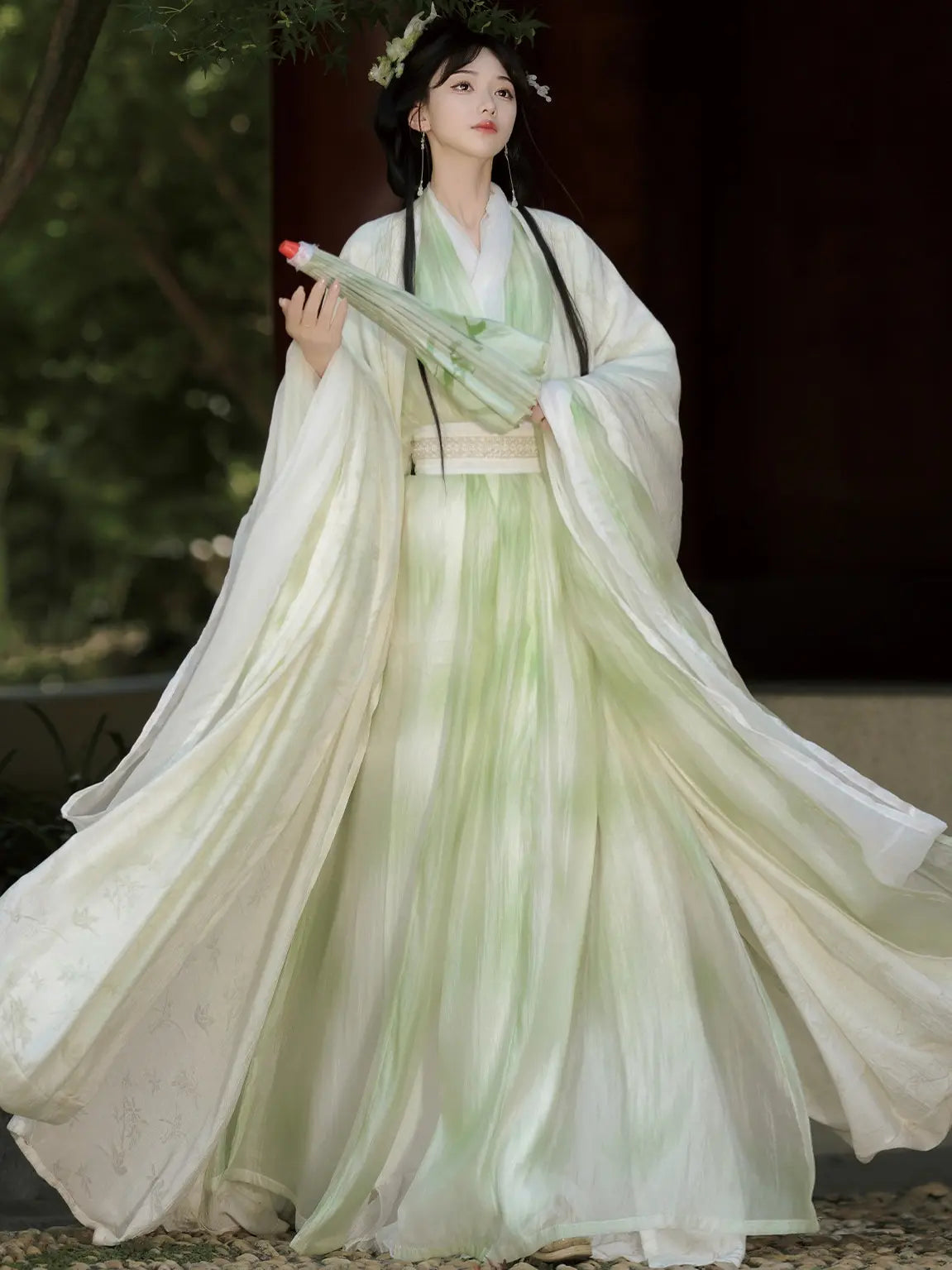 Person wearing a Sage Green Traditional Wei-Jin Style Double-Layer Hanfu Dress Set  with flowing sleeves against a blurred natural background