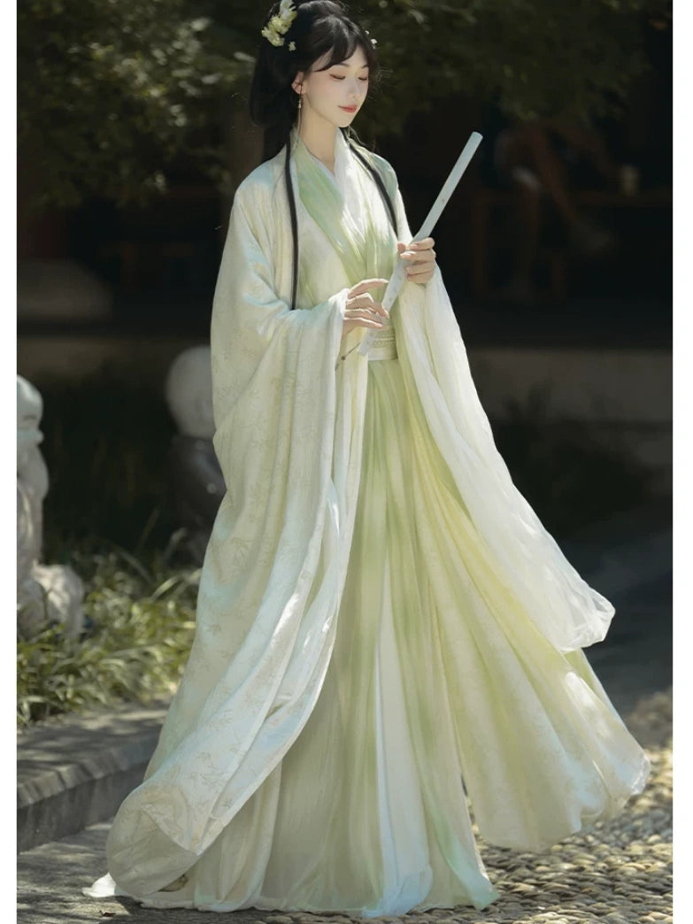 Person in Sage Green Traditional Wei-Jin Style Double-Layer Hanfu Dress Set holding a sword outdoors